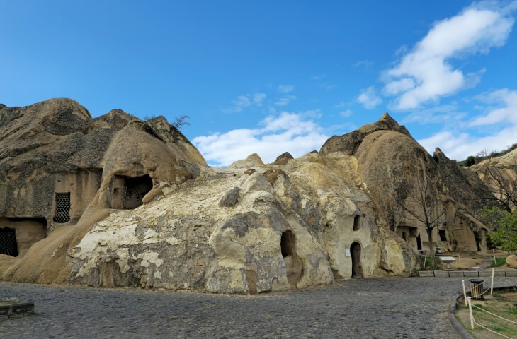 Göreme Açık Hava Müzesi’nde yer alan Aziz Basil Şapeli’nin dış cephesi; yuvarlak hatlı kaya oluşumlarının içine oyulmuş girişlerle birlikte görülüyor.